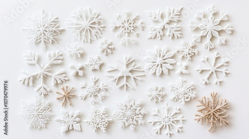 Different white snowflakes arranged on a white table create a stunning flat lay. This flat lay design highlights the beauty of the white snowflakes in an elegant composition.