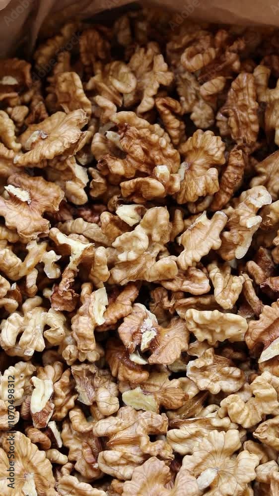Pile of raw walnuts. Vertical video. Top view. Close-up. Pile of raw walnuts. Vertical video. Top view. Close-up.