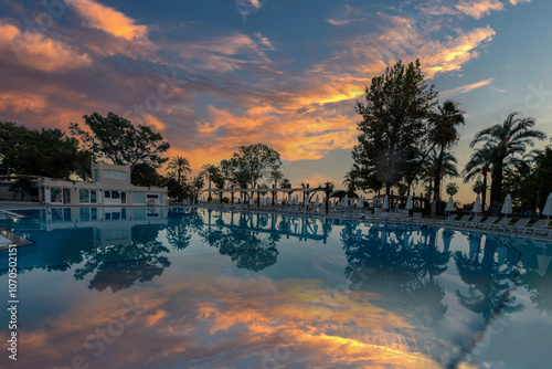 Obraz na płótnie Magnificent view, swimming pool at sunset. Holiday hotel in Antalya. Great relaxation and peaceful atmosphere, trees, reflections of sun loungers. w salonie