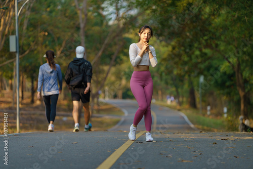 Asian woman jogging in the park smiling happy running and enjoying a healthy outdoor lifestyle. Female jogger. Fitness runner girl in a public park. healthy lifestyle and wellness being a concept.