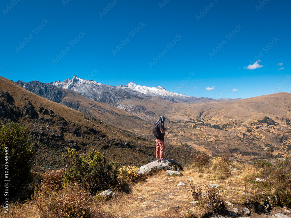 Young White Man Stands on a Rock Admiring the Mountains on his Way to the Churup Lagoon in Ancash, Peru