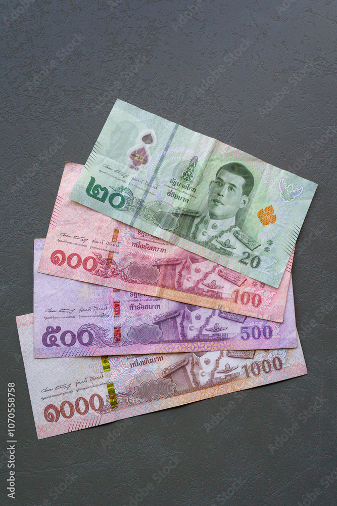 Thai Baht Banknotes on Table. Close-up of Thai Baht banknotes spread on a table, highlighting the currency.