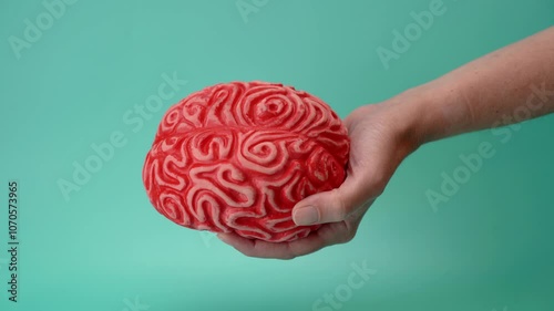 Hand with red brain against green background
