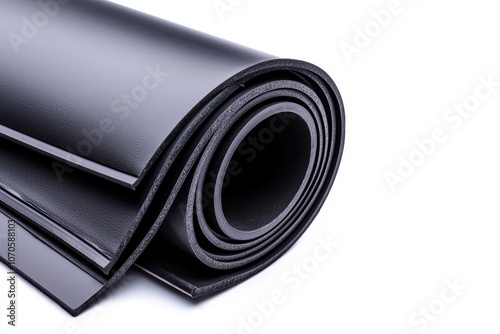 Rolled sheet of black rubber material on a white isolated background. photo