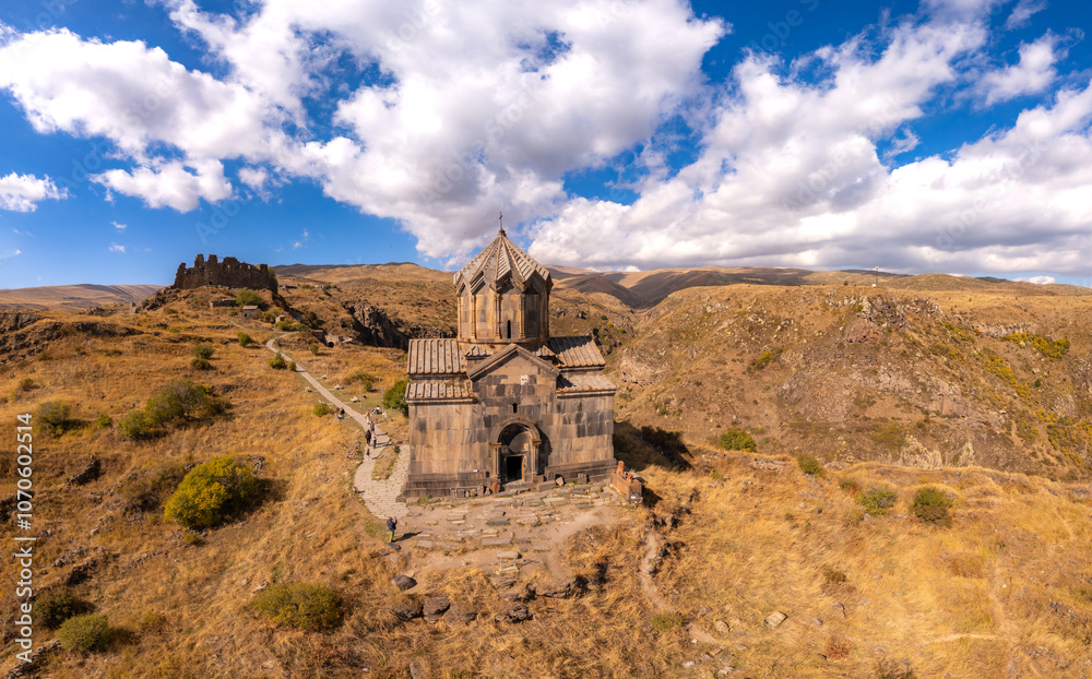 Fototapeta premium Aerial drone view of famous Vahramashen Church of the 11th century, located near destroyed Amberd fortress in sunny summer day. Cliff with Arkashian River deep in canyon. Aragatsotn region, Armenia