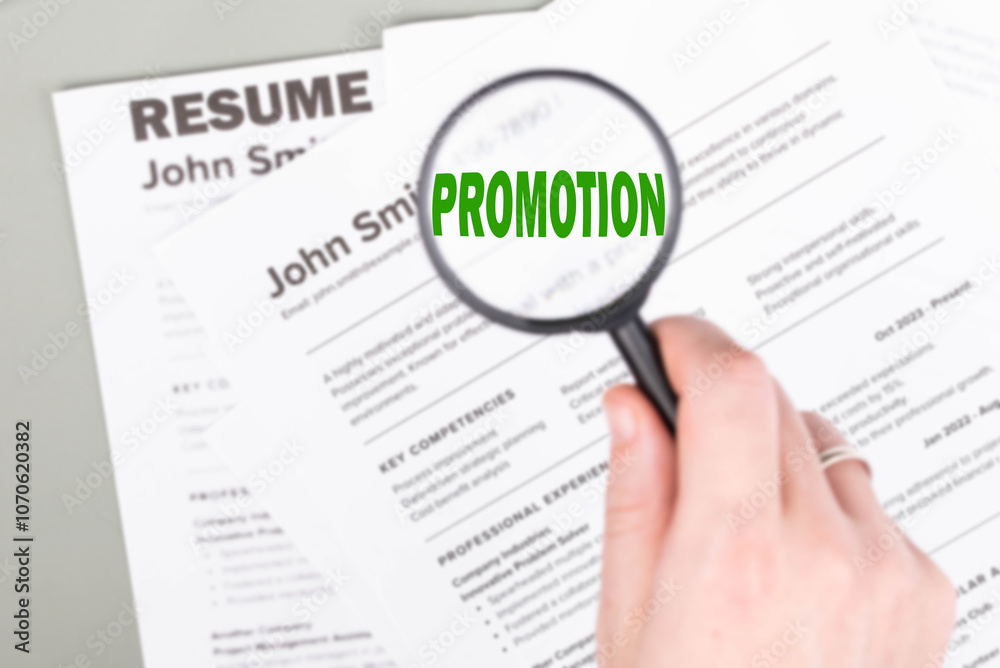 Mock CV (curriculum vitae) for John Smith with a magnifying glass highlighting Candidate for promotion. Concept of career advancement, talent recognition, and promotion process within the workplace. Mock CV (curriculum vitae) for John Smith with a magnifying glass highlighting Candidate for promotion. Concept of career advancement, talent recognition, and promotion process within the workplace.