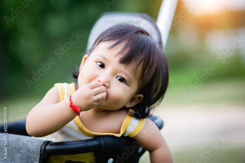 Young asian woman mother, walking with baby stroller in park