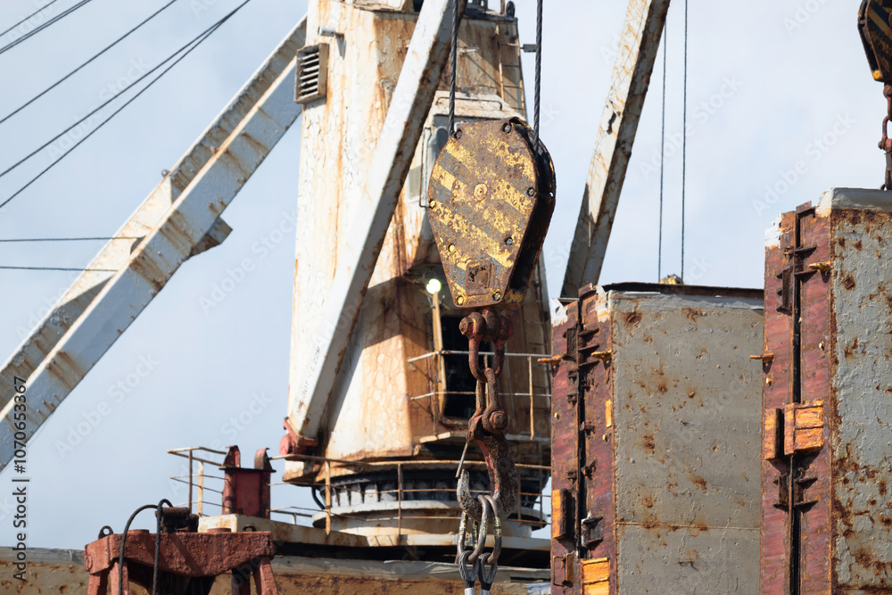Fototapeta premium A rusty hook of the deck crane is used for loading many containers to the holds of the ship.