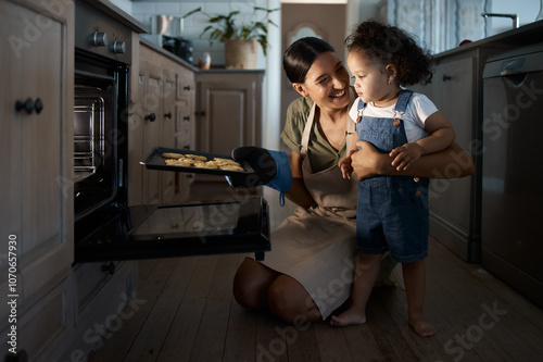 Cookies, mom or toddler baking with oven, tray or food for bonding or lesson in family home. Happy parent, night or mother teaching kid cooking skill for child development, learning or breakfast meal photo