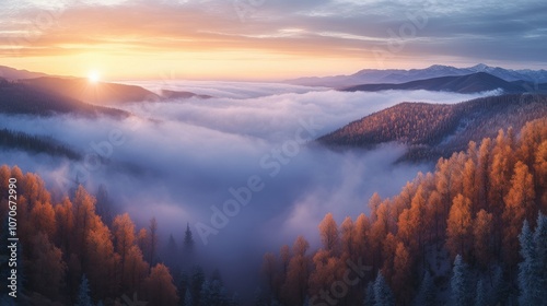 Breathtaking sunrise over a misty valley, framed by vibrant autumn foliage and majestic mountains in the background.