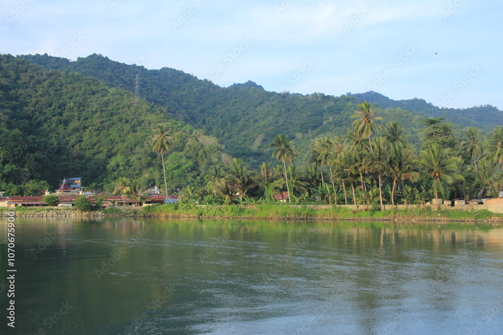 the beautiful and calm atmosphere of the village at the foot of the hill on the edge of the river estuary the beautiful and calm atmosphere of the village at the foot of the hill on the edge of the river estuary