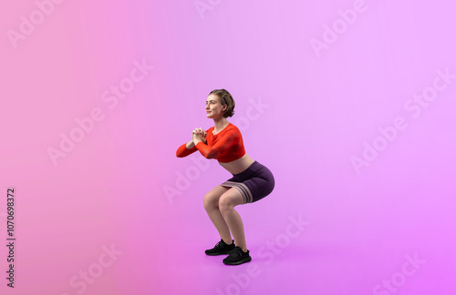 Full body length gaiety shot athletic and sporty young woman with fitness elastic resistance band in squat exercise posture on isolated background. Healthy active and body care lifestyle.