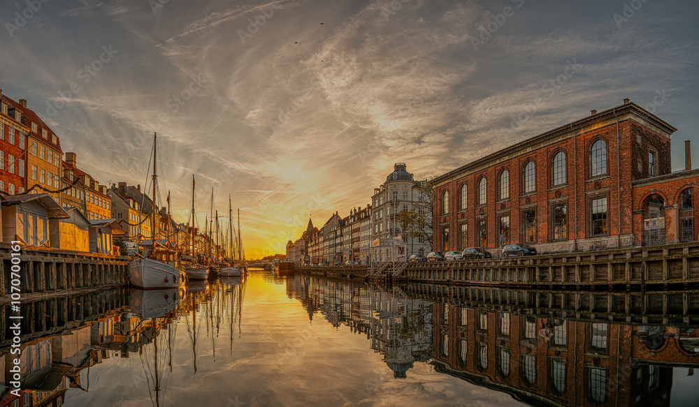 Sunrise over Nyhavn in Copenhagen with reflections in the mirrored canal