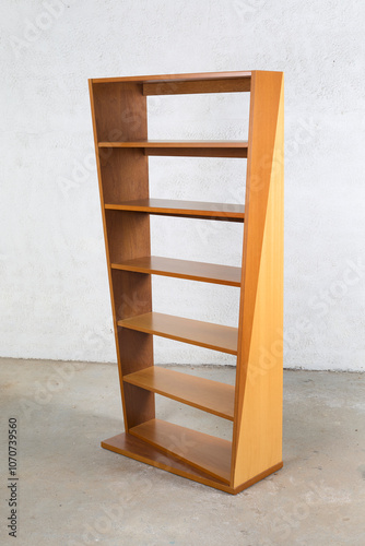 Vintage twisted bookshelf with cascading widths. Made from a mix of woods - teak, walnut, and beech wood grain.s. Interior product photograph. photo