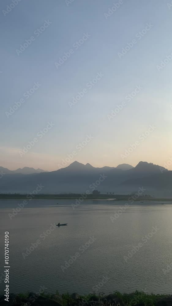 a fisherman on Selorejo Lake with a view of Mount Kelud a fisherman on Selorejo Lake with a view of Mount Kelud