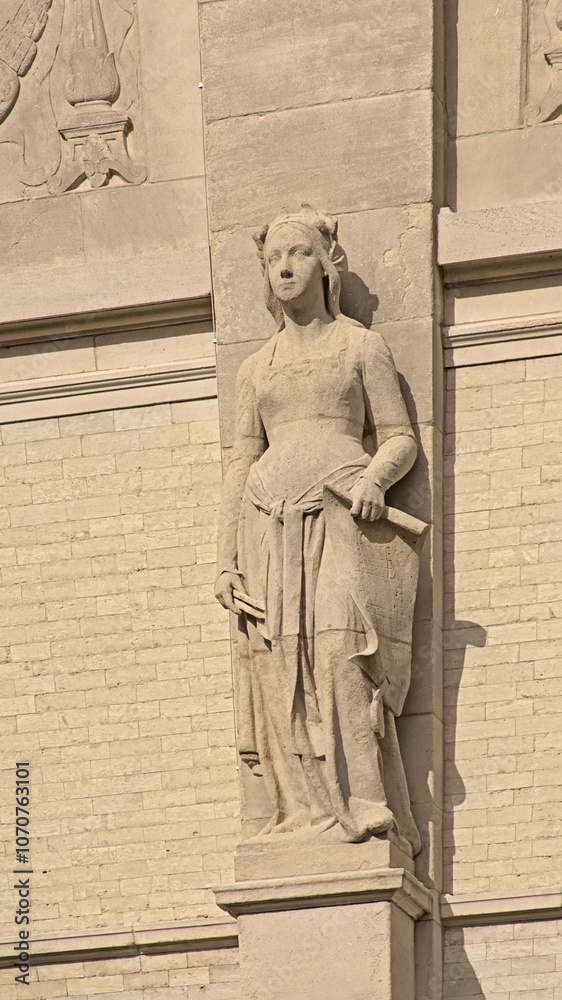 Fototapeta premium Statue of a woman holding a scroll, architecure detail of the Royal Museum of Fine Arts in neo-classical style Antwerp, Flanders, belgium