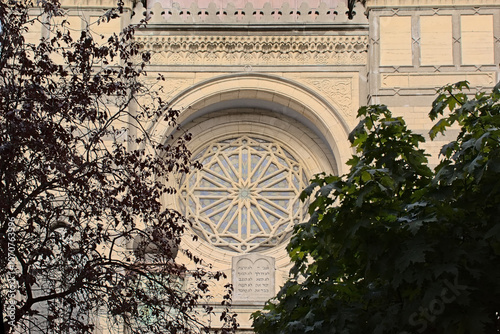 Rose window of the Hollandse Synagogue , framed by trees. Antwerp, Belgium, low angle view 