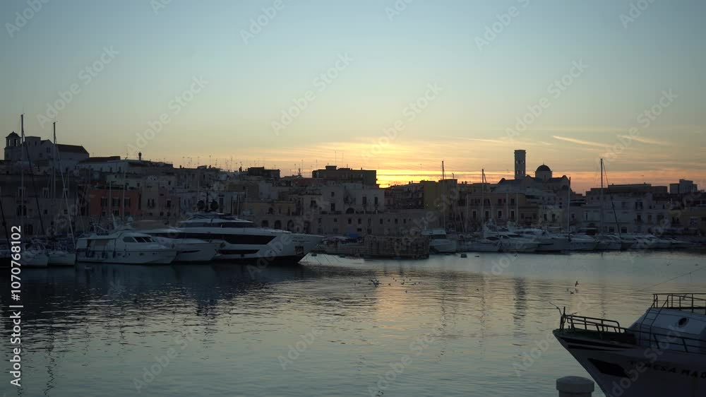 View of seafront, port and the old town Bisceglie in Puglia on sunset.