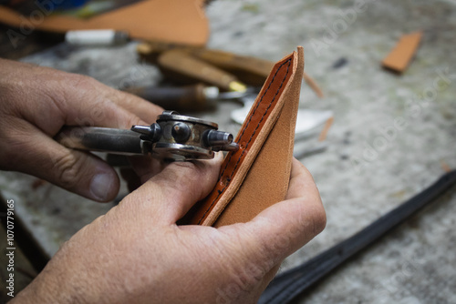 A saddler craftsman restores and creates animal harnesses and tack with leather. He cuts, glues, sews, paints.