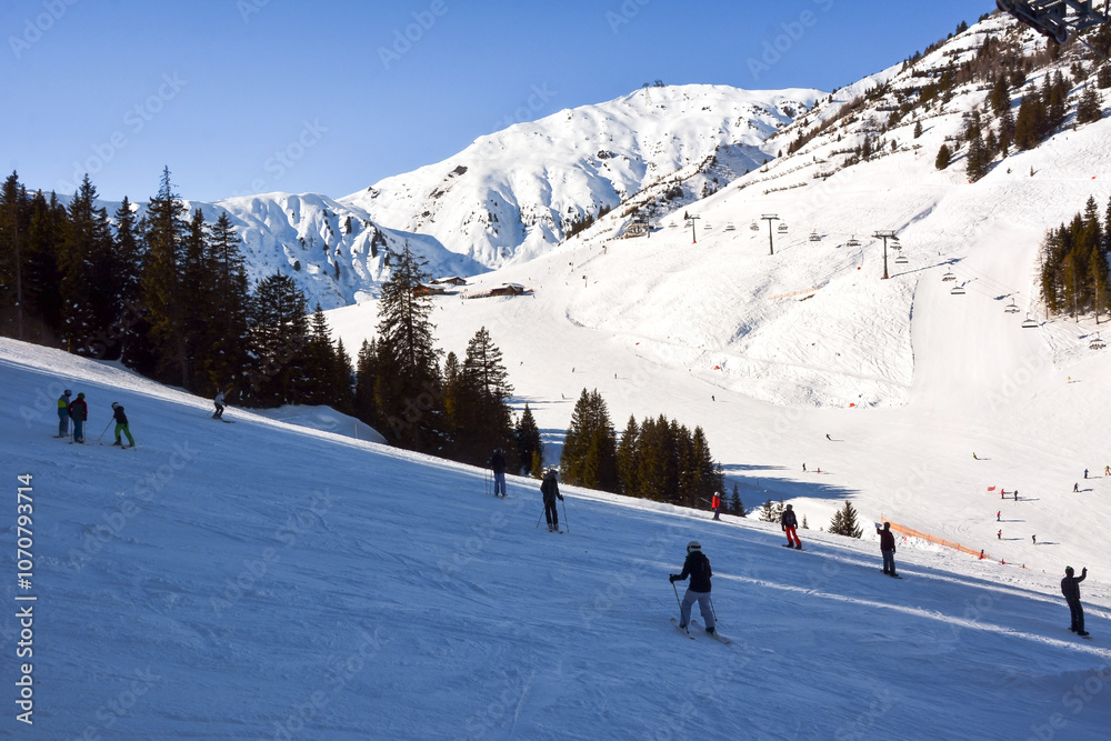 The ski slopes of the track on which skiers and snowboarders descend. A view from afar. Hotel buildings are also visible. Winter sports and recreation The ski slopes of the track on which skiers and snowboarders descend. A view from afar. Hotel buildings are also visible. Winter sports and recreation