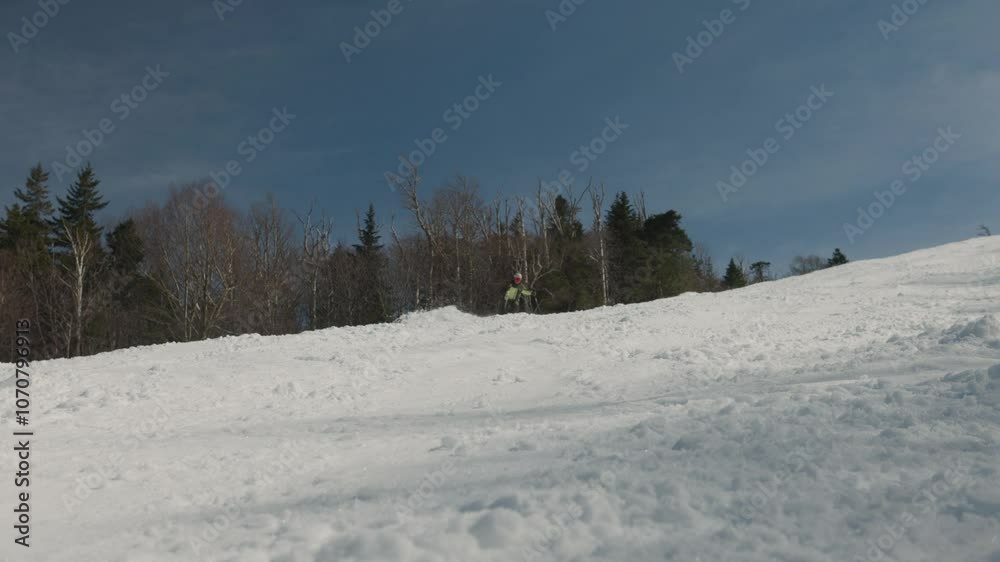 Male skier making a skiing turn on a winter day with sunshine and soft snow on a nice trail on a mountain. Adventure and thrill with alpine sports. Vermont, New England, USA. Male skier making a skiing turn on a winter day with sunshine and soft snow on a nice trail on a mountain. Adventure and thrill with alpine sports. Vermont, New England, USA.