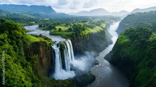 A view of the Blue Nile Falls, with water cascading over the cliffs into the river below, surrounded by lush greenery.