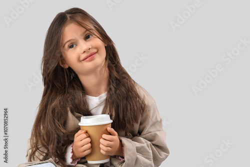 Little girl with cup of cocoa on light background, closeup