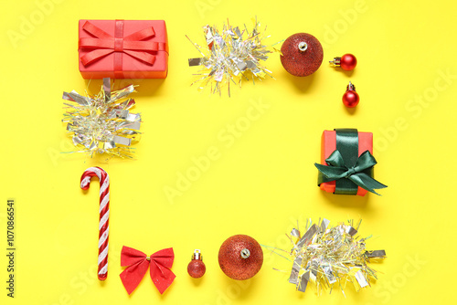 Frame made of Christmas decorations and gifts on yellow background photo