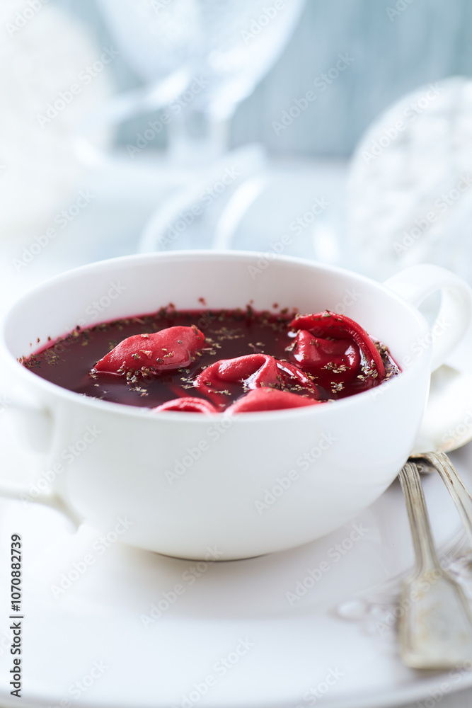 Traditional Christmas Borscht (Barszcz) with mushroom dumplings on bright background.