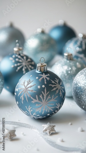 Decorative blue Christmas ornaments with snowflake designs on a soft white background