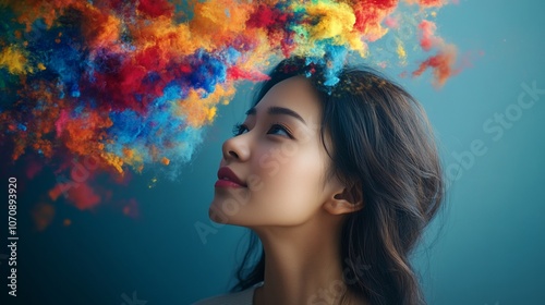 Woman looking up at colorful cloud of paint.