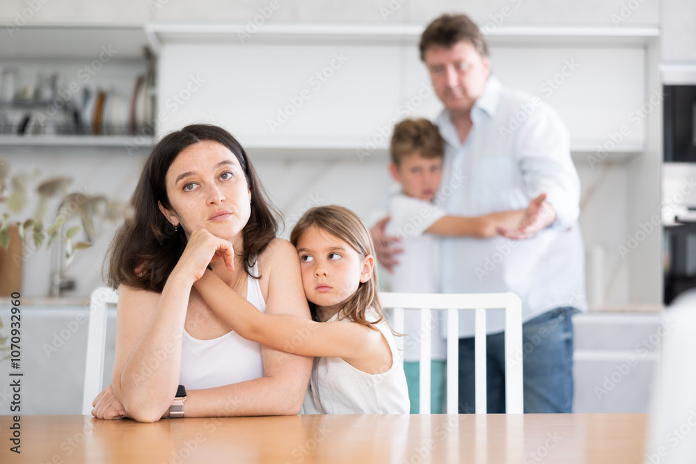 Domestic quarrel in big family - little daughter hugging upset mom, son hugging sad father Domestic quarrel in big family - little daughter hugging upset mom, son hugging sad father