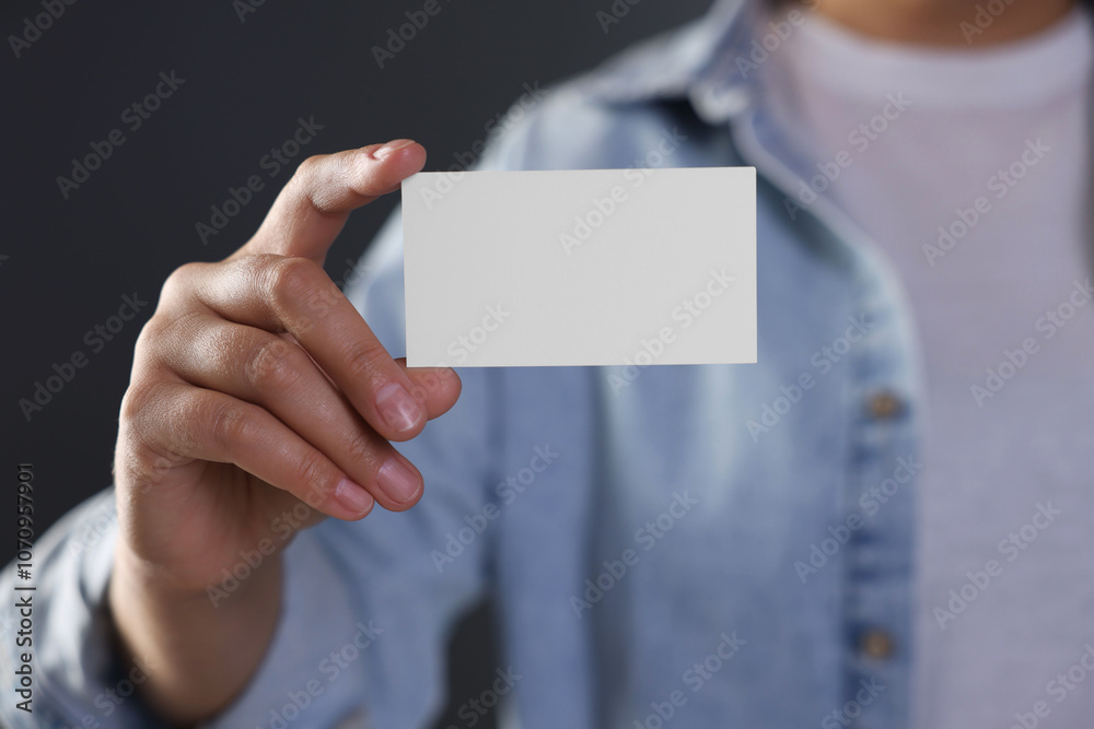 Woman holding blank business card on grey background, closeup. Mockup for design Woman holding blank business card on grey background, closeup. Mockup for design