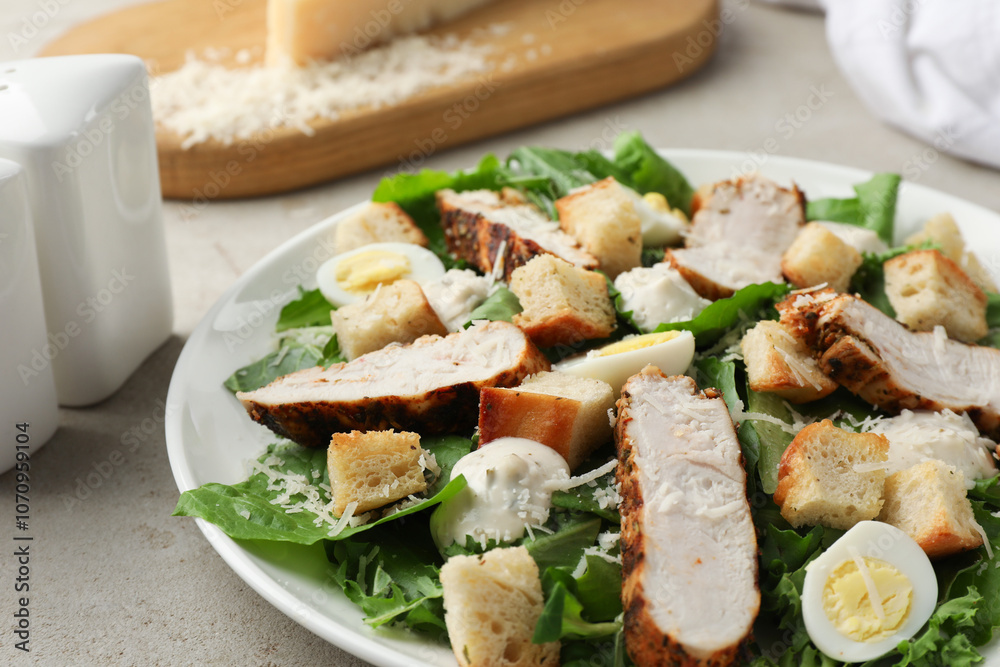 Tasty Caesar salad with chicken on light grey table, closeup Tasty Caesar salad with chicken on light grey table, closeup