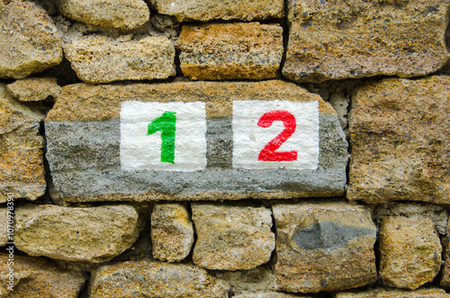 Colorful Number 12 Painted on a Stone Wall in an Outdoor Setting