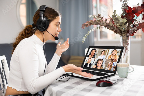 Young woman working from home, communicating with business colleagues by video conference photo