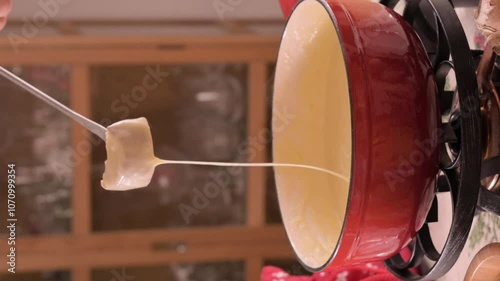 Cozy Swiss fondue setup with melted cheese, bread, pickles, and wine on a rustic table. advertising, social media campaigns, or food-related promotions. High quality 4k footage