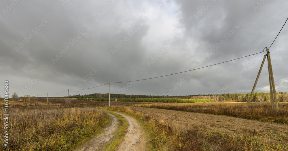 A road in a field with a wire line running across it A road in a field with a wire line running across it