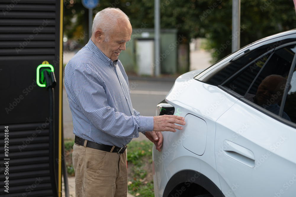 Senior Man Preparing to Charge Electric Car at Charging Station Senior Man Preparing to Charge Electric Car at Charging Station