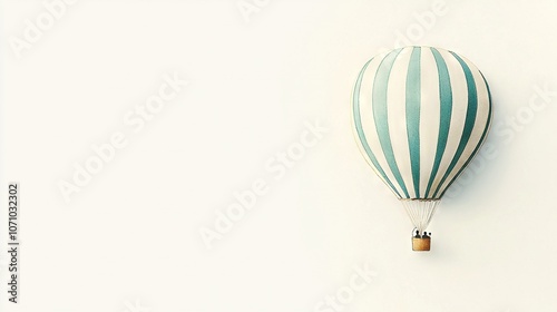   A green and white striped hot air balloon resting on a white wall, attached to a wooden stick at its base photo