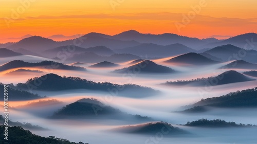  A mountain range in fog with a distant setting sun