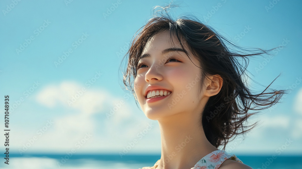 A woman smiles brightly at the beach, her hair flowing in the wind A woman smiles brightly at the beach, her hair flowing in the wind