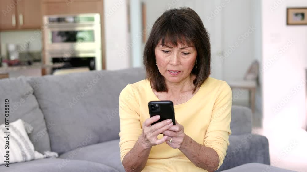 Smiling woman enjoying smartphone reading texting sitting in home living room. Smiling woman enjoying smartphone reading texting sitting in home living room.