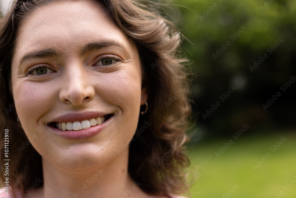 Smiling woman enjoying sunny day outdoors in lush green garden, copy space Smiling woman enjoying sunny day outdoors in lush green garden, copy space