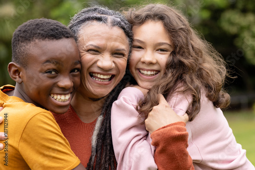 Smiling mutliracial family embracing outdoors, sharing joyful moment together photo