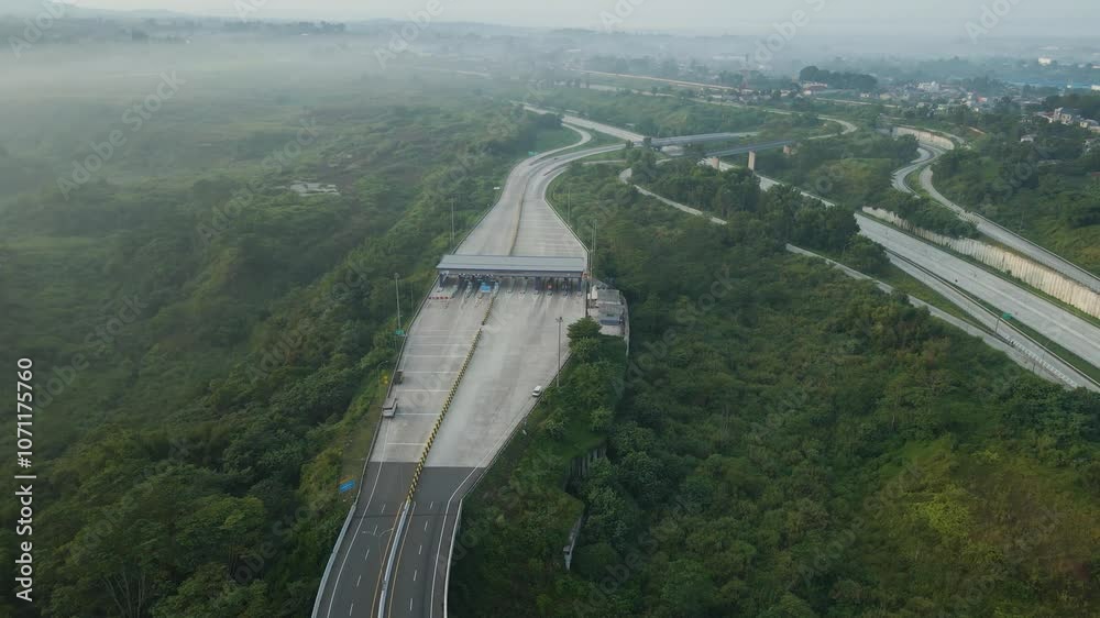 drone video of the car entering the toll road gate which is built very beautifully with a refreshing morning mist atmosphere, drone to the right and camera to the front
drone video of the car entering the toll road gate which is built very beautifully with a refreshing morning mist atmosphere, drone to the right and camera to the front