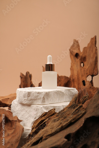 Frosted Glass Dropper Bottle on White Pedestal with Rustic Wooden Background photo