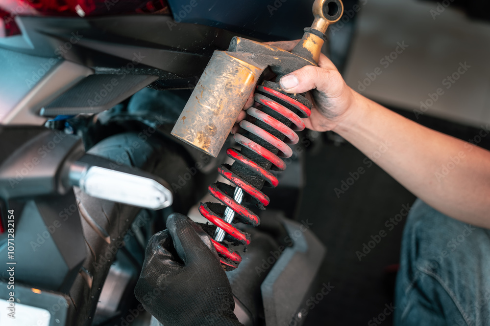 Motorcycle mechanic check and change rear Shock Absorbers motorcycle at motorcycle garage, Damaged Struts and fluid leaks among struts and shocks , repair, maintenance and service concept