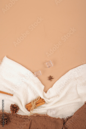 Rustic Flatlay with White Fabric, Cinnamon Sticks, and Star Anise on Neutral Background photo