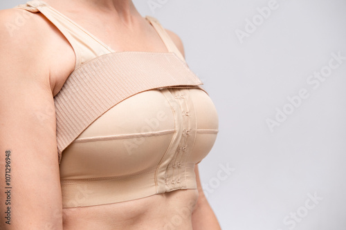 woman patient In post surgical Compression bra, implants stabilizer bra after plastic surgery medical mammoplasty, mastopexy breast enlargement, on white background